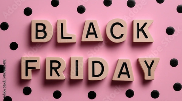 Fototapeta Black Friday Deals Typography: A stylish and inviting composition featuring BLACK FRIDAY spelled out in wooden letters, set against a pastel pink polka dot backdrop.