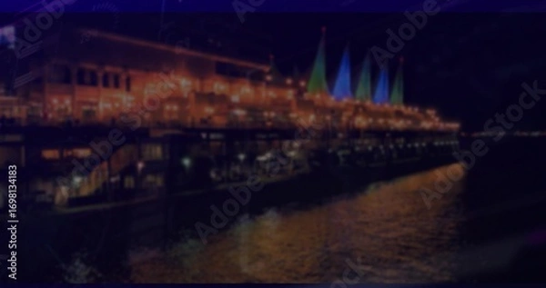 Obraz Glowing pier-side restaurant with string lights and sail structures, reflecting water patterns