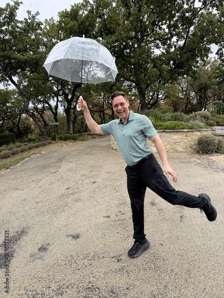 Fototapeta Happy Man Posing Playfully with an Umbrella on a rainy day