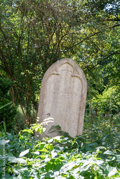 Fototapeta Alter Grabstein mitten in einem Strauch  Alter Südfriedhof München