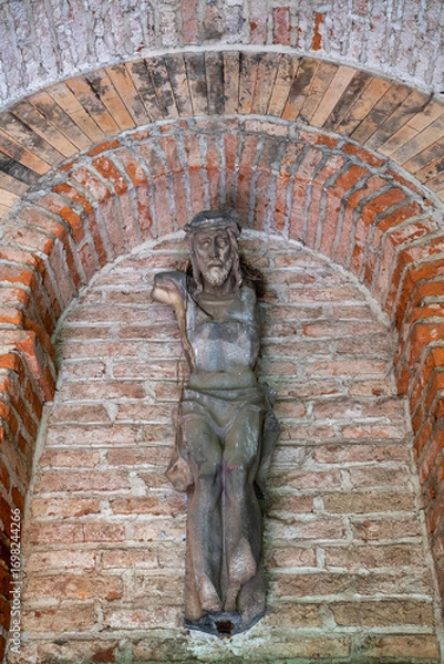 Obraz sehr alte Jesusfigur ohne Arme an einer Ziegelwand Alter Südfriedhof München