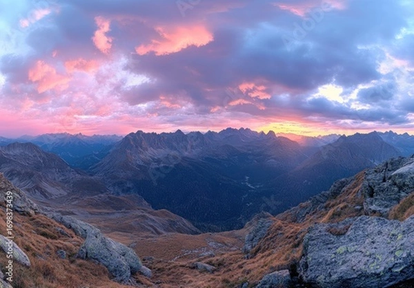 Fototapeta A breathtaking panoramic view of the Dolomites mountain range at sunset, showcasing its majestic peaks and colorful sky in autumn.