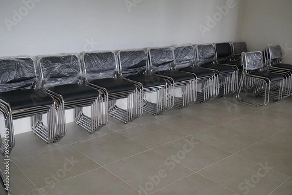 Fototapeta Row of chairs are lined up on a tile floor