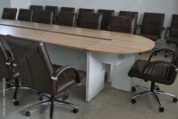 Fototapeta Large wooden table with many chairs around it