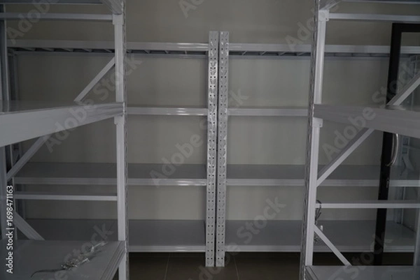 Fototapeta Large, empty white storage room with two shelves