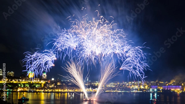 Obraz Blue fireworks over the Saint-Lawrence River with a part of Quebec city in the background. Quebec, Canada.