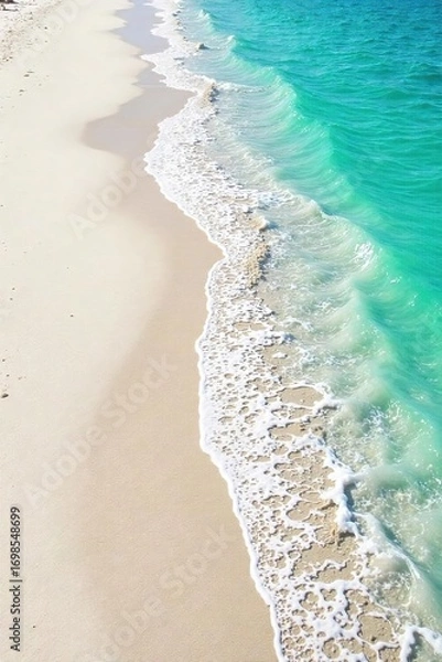 Fototapeta Fine, white sand stretches along a pristine shoreline, gently lapping waves creating delicate textures  Perfect for travel, nature, and coastal themed projects ,  serenity,  calm