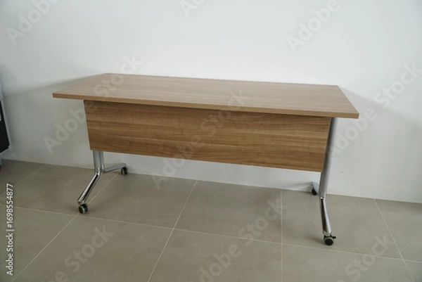 Fototapeta Wooden table with a black wheel on the bottom