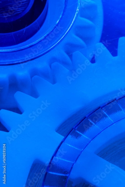 Obraz Abstract macrophotography interlocking white gears illuminated with blue light, emphasizing innovation, mechanics, and technology.