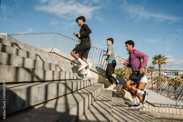 Fototapeta A group of five athletes running up the stairs