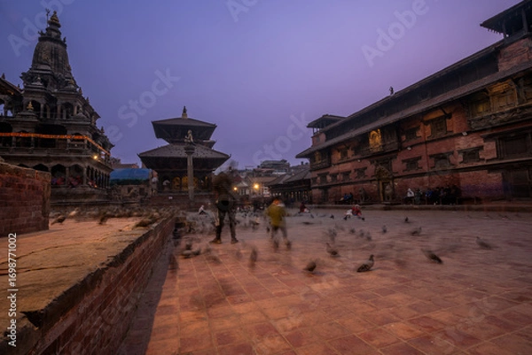 Fototapeta Magic view of Patan Durbar Square in Kathmandu, Nepal. Traditional Newari architecture with illuminated temples and purple sky. Historical UNESCO World heritage with cultural and architectural beauty.