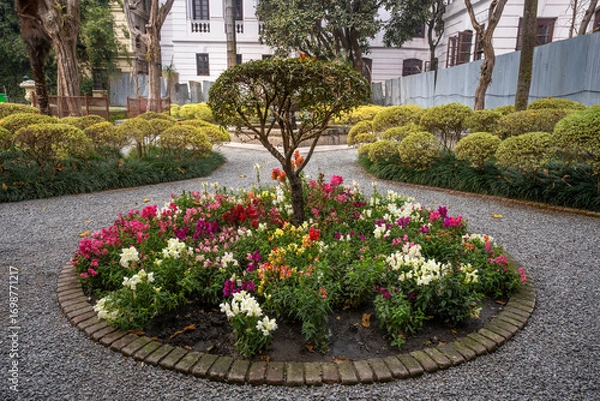 Fototapeta Tranquil view of the Garden of dreams in Kathmandu, Nepal. Beautiful landscaped garden with stone pathways, water fountains, blooming trees and elegant classical architecture offering a serene escape.