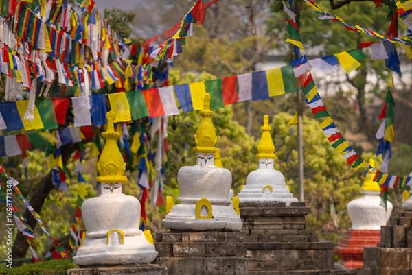 Fototapeta Colorful prayer flags and traditional Buddhist stupas in Swayambhunath area, known as monkey temple, Kathmandu, Nepal. Peaceful atmosphere and colorful flags reflecting Nepalese culture and religion.