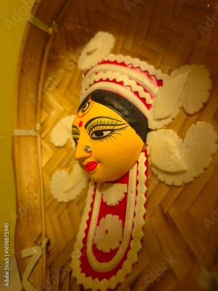 Fototapeta handcrafted wall hanging depicting the stylized face of Ma Durga, created for Durga Puja celebrations.