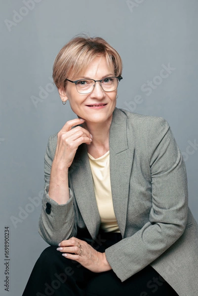 Obraz Portrait of happy woman. Confident, successful mature woman on light gray background. Looking at camera. High quality photo