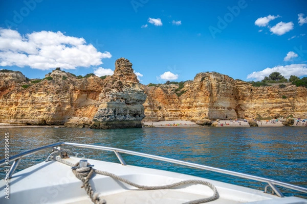 Fototapeta Beautiful rock formations cliffs caves geology grottos of the Portugal southern Algarve coast with beaches people and kayaks near Benagil seen from water calm ocean copy space travel nature background