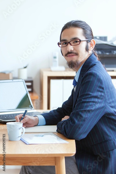 Fototapeta デスクワークをする眼鏡をかけたビジネスマン