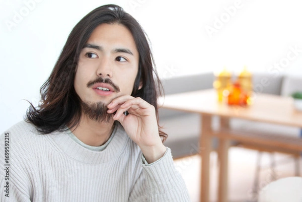 Fototapeta 考え事をするロングヘアの男性