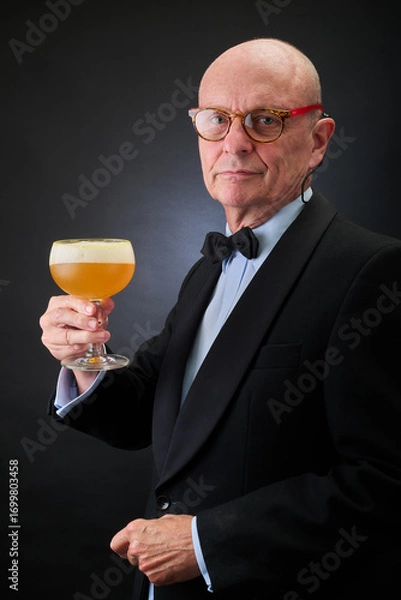 Fototapeta Portrait of a serene aged and balded man with bow tie and tuxedo suit