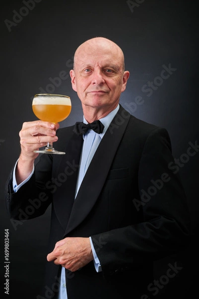 Fototapeta Portrait of a serene aged and balded man with bow tie and tuxedo suit