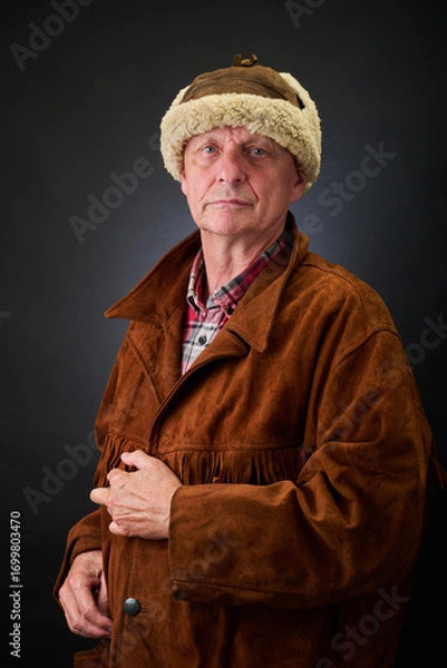 Fototapeta Portrait of a serene aged cowboy trapper in studio