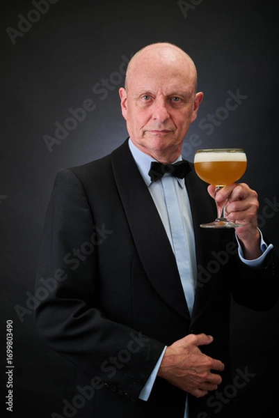 Fototapeta Portrait of a serene aged and balded man with bow tie and tuxedo suit
