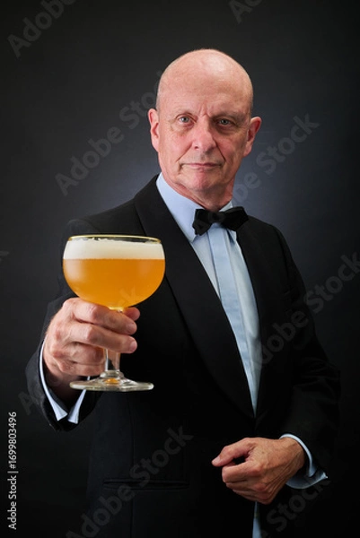Fototapeta Portrait of a serene aged and balded man with bow tie and tuxedo suit