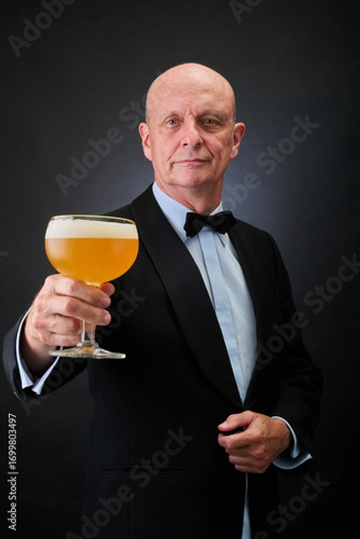Fototapeta Portrait of a serene aged and balded man with bow tie and tuxedo suit