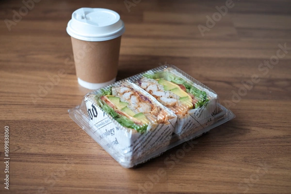 Fototapeta sandwich with filling in a plastic box with coffee in the morning.