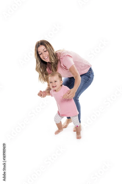 Fototapeta baby girl learning to walk with the help of her mother