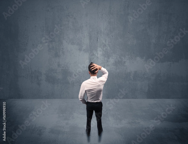 Fototapeta Businessman standing in front of urban wall