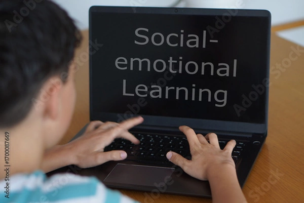 Fototapeta Social and Emotional Learning in Schools Concept. Adolescent Child Using a Laptop with Words Written on the Screen