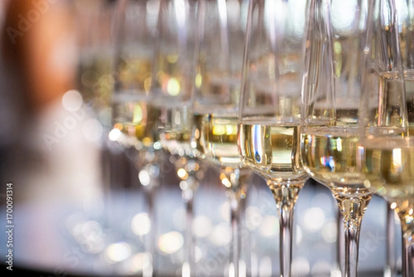 Fototapeta Close-up of champagne glasses filled with sparkling wine, elegant celebration table setting for festive party, wedding, New Year or luxury corporate event