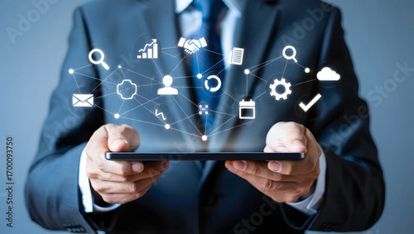 Fototapeta Businessman in suit using a smartphone with digital icons and network connections floating above