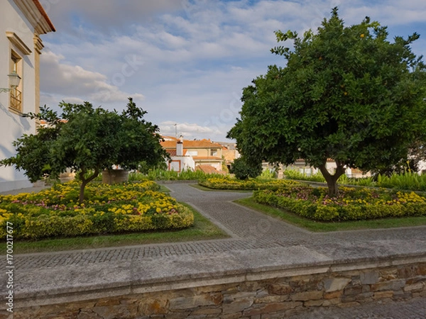 Fototapeta Garden in Mirandela, Portugal. Decorative flower beds, lush trees, and paved paths create a tranquil urban haven known as the garden city of the Tua Valley.