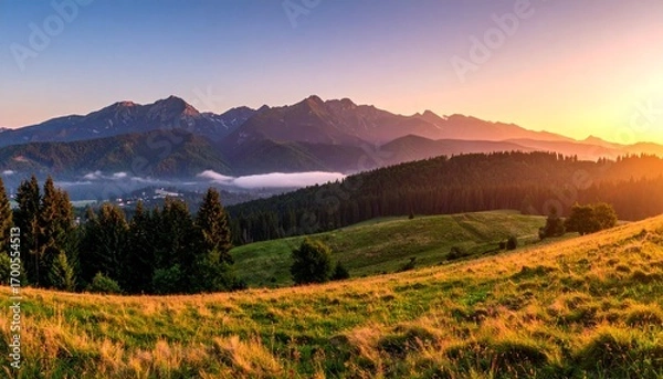 Fototapeta Snow-patched mountains, mist-filled valleys, evergreen forests, and sunlit meadows under a gradient sky, evoking serenity, natural diversity, and the quiet magic of dawn or dusk.