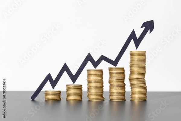 Fototapeta Stacks of coins and rising arrow on gray background indicating positive financial growth, business success concept. Copy space