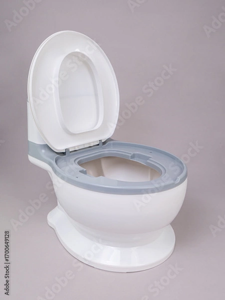 Obraz White with gray stripe children's plastic potty in the form of a toilet with an open lid on a gray background