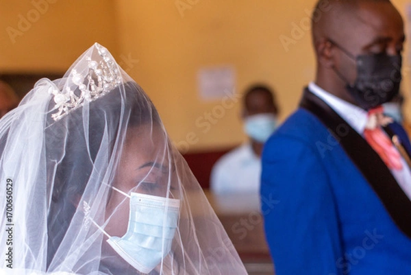 Obraz African Bride in Focus with Groom Beside, Both Wearing Disposable Face Masks