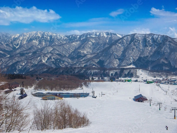 Fototapeta A wide ski slope with chairlifts, a restaurant and a pond at middle of Tsugaike Mountain Resort (Hakuba, Nagano, Japan)