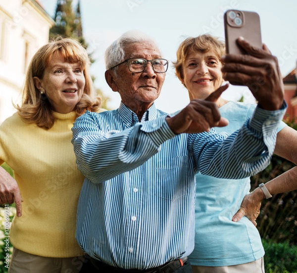 Fototapeta Joyful older adults happily taking a fun selfie together in a beautiful autumn park setting