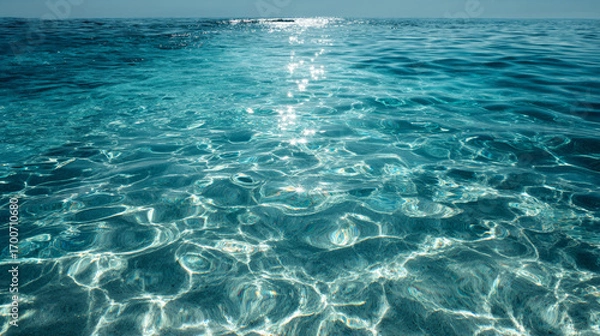 Fototapeta Gentle waves creating abstract patterns on water surface in sunlight