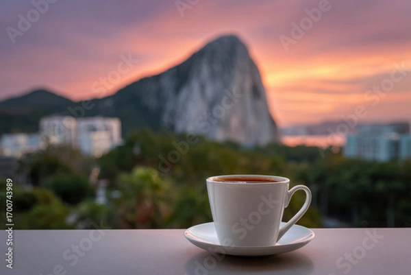 Fototapeta steaming cup of coffee sits invitingly on clean surface creating cozy atmosphere against breathtaking natural