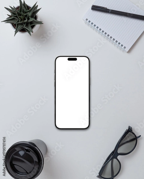 Fototapeta Smartphone with blank screen on office desk with accessories