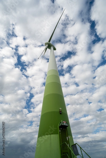 Fototapeta Windkraftanlage aus der Froschperspektive vor dynamischem Wolkenhimmel – Symbol für erneuerbare Energien