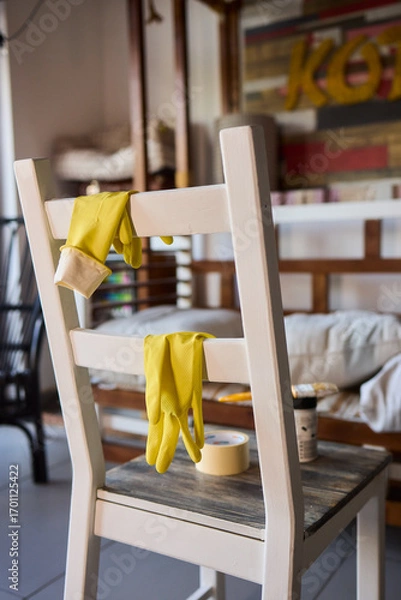 Fototapeta Engage in DIY chair restoration using a paint brush and protective gloves for the process