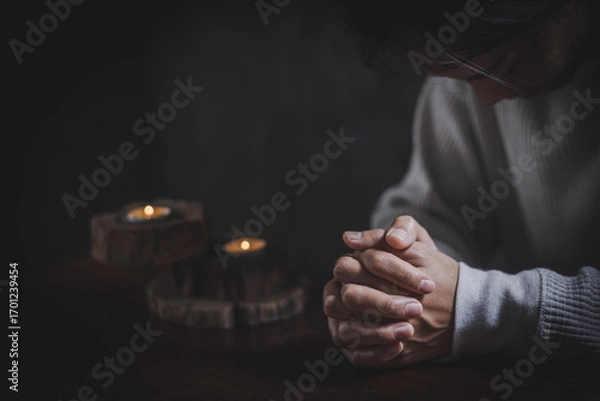 Fototapeta woman's hands clasped together in a moment of prayer or deep contemplation showcasing inner thoughts.