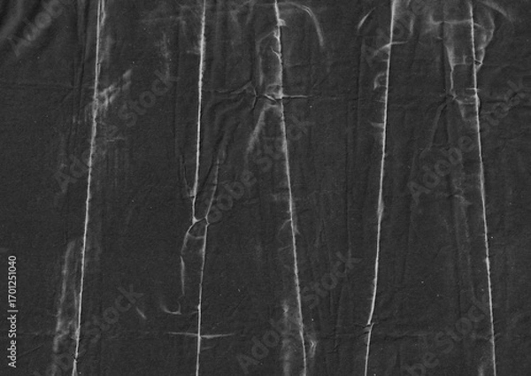Fototapeta Creased black paper texture background. Monochrome crumpled grunge paper graphic element. Folded surface with abstract lines for overlay design.