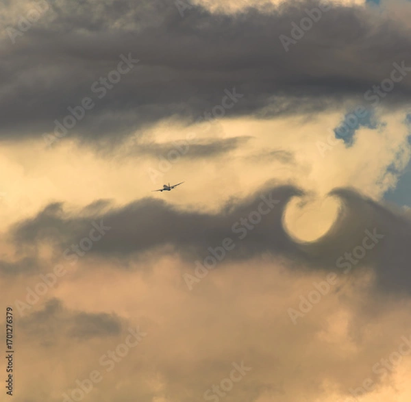 Obraz 飛行機　美しい 　光　雲　空　を背景に飛ぶ　航空機