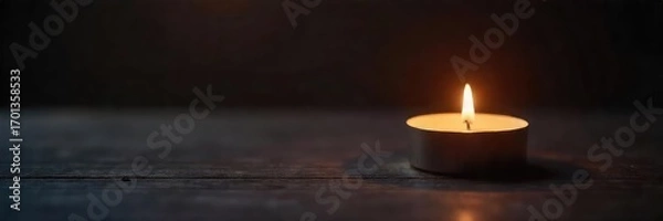Fototapeta A single flickering candle casts a warm, inviting glow on a dark wooden surface, creating a peaceful and serene ambiance Perfect for relaxation, meditation, or spiritual themes , decor, still life